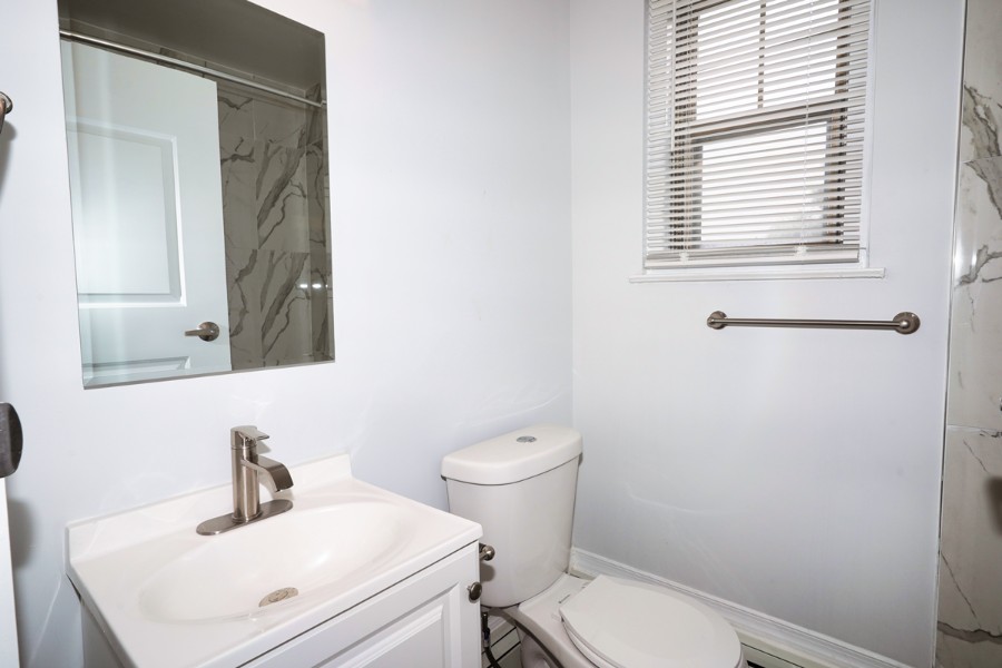 bathroom with ceramic sink, mirror, and toilet