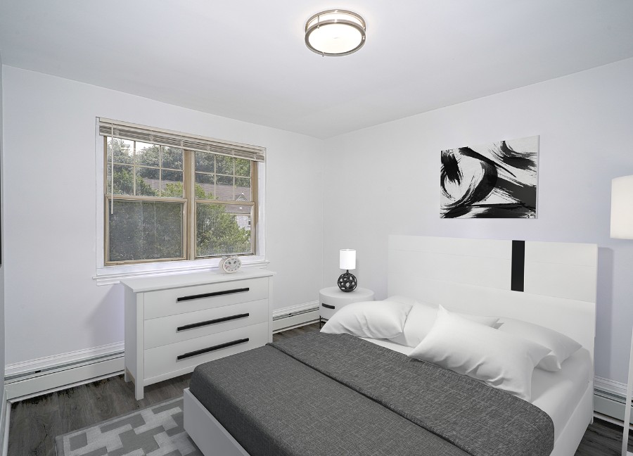 staged bedroom with grey sheets and modern painting