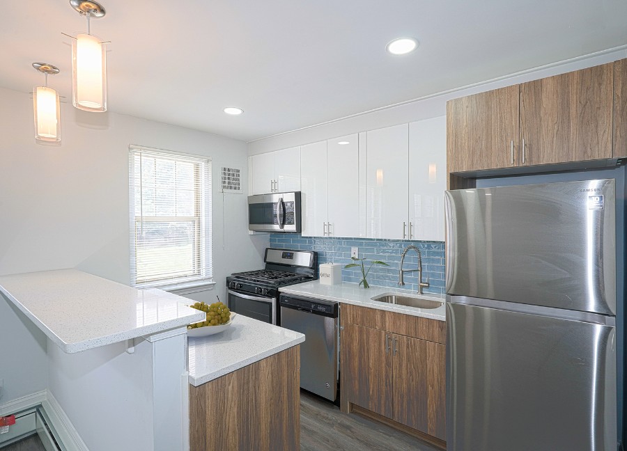 kitchen with blue tile backsplash and modern appliances