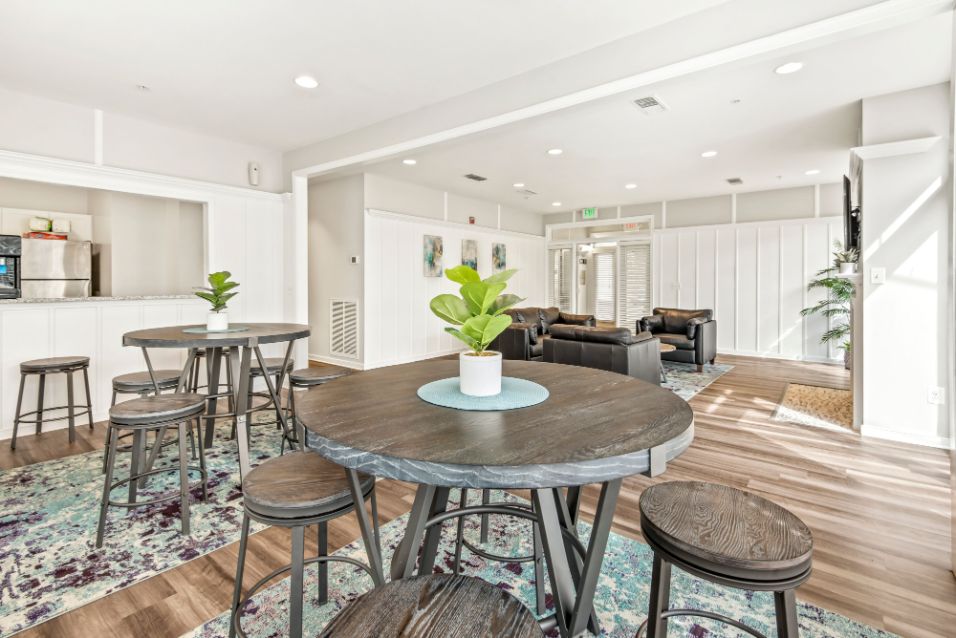Two dining tables with living space and kitchen in the back