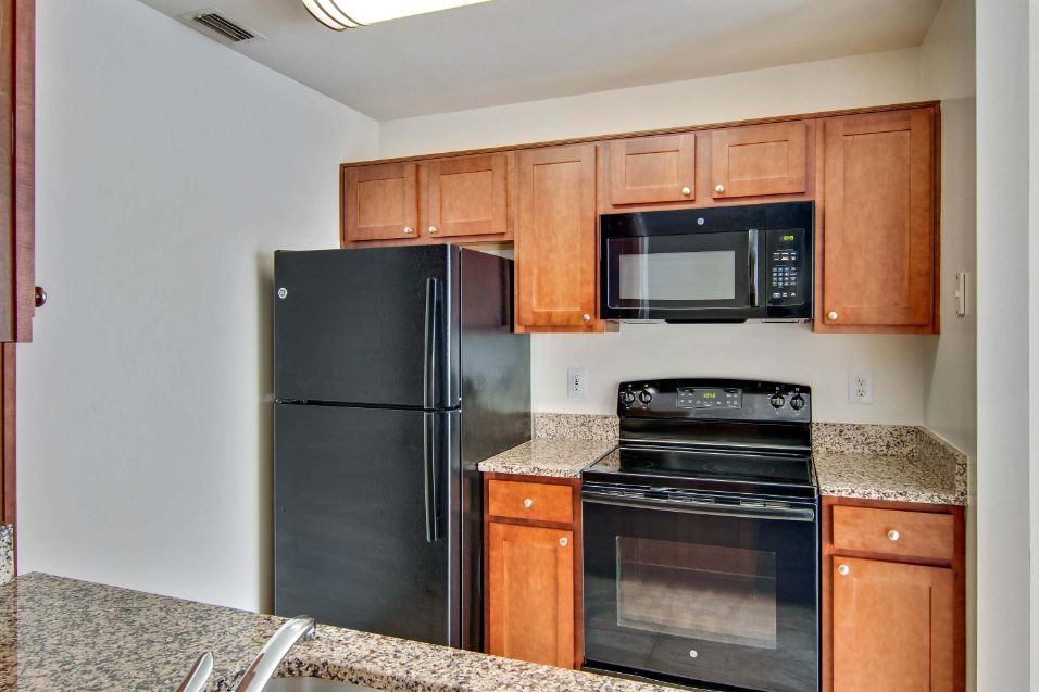 light cherry-colored cabinets with black appliances